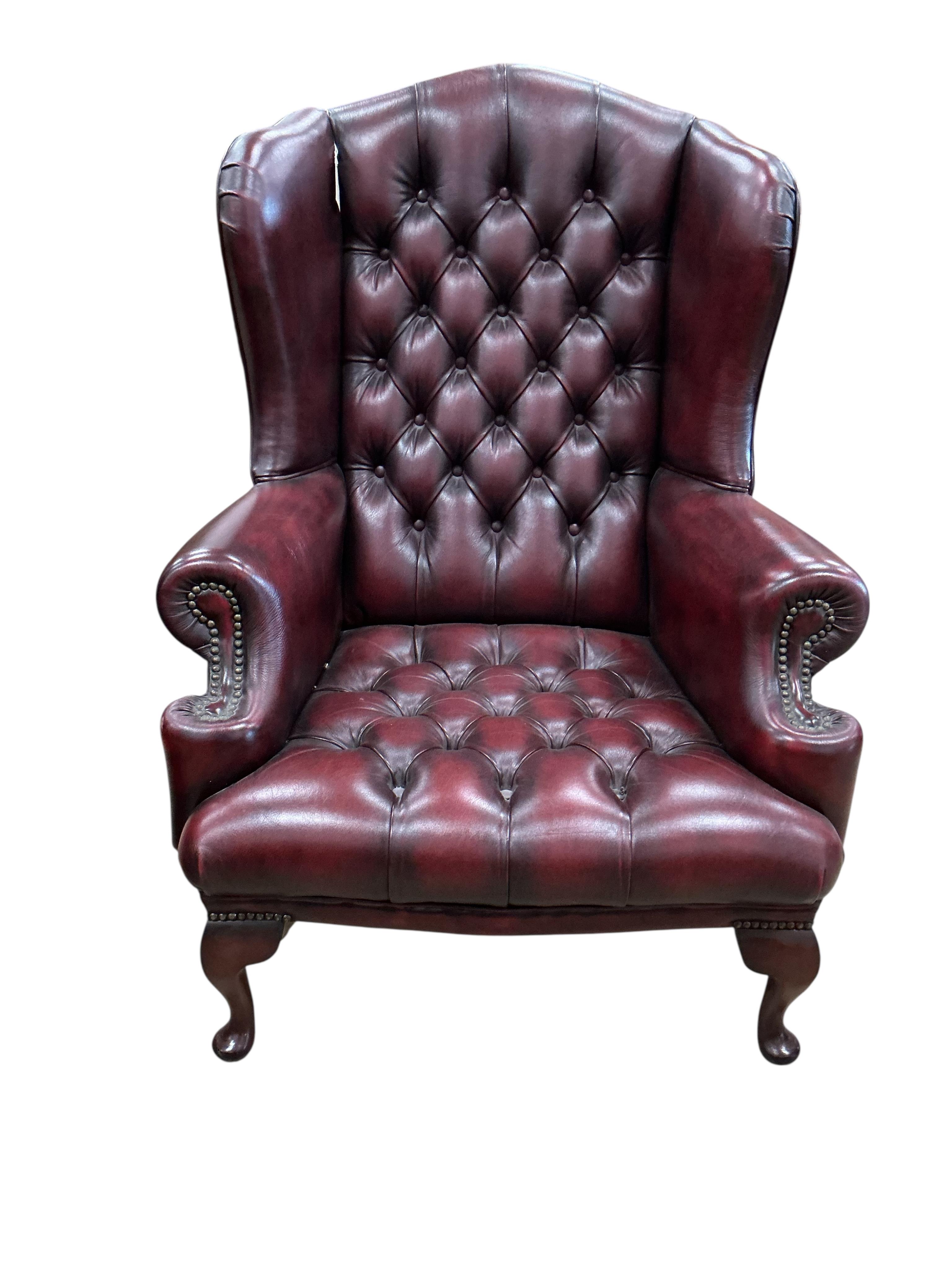 A pair of reproduction buttoned burgundy leather wing armchairs, width 82cm, depth 70cm, height 104cm